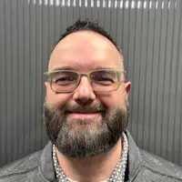 Professional headshot of Andy Wright, a smiling man with glasses and a beard.