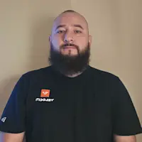 Professional headshot of Kevin G., a bearded man wearing a black Velociti t-shirt.
