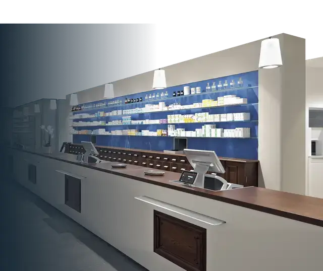 Modern retail pharmacy counter with point-of-sale terminals and organized product shelving against a blue wall.