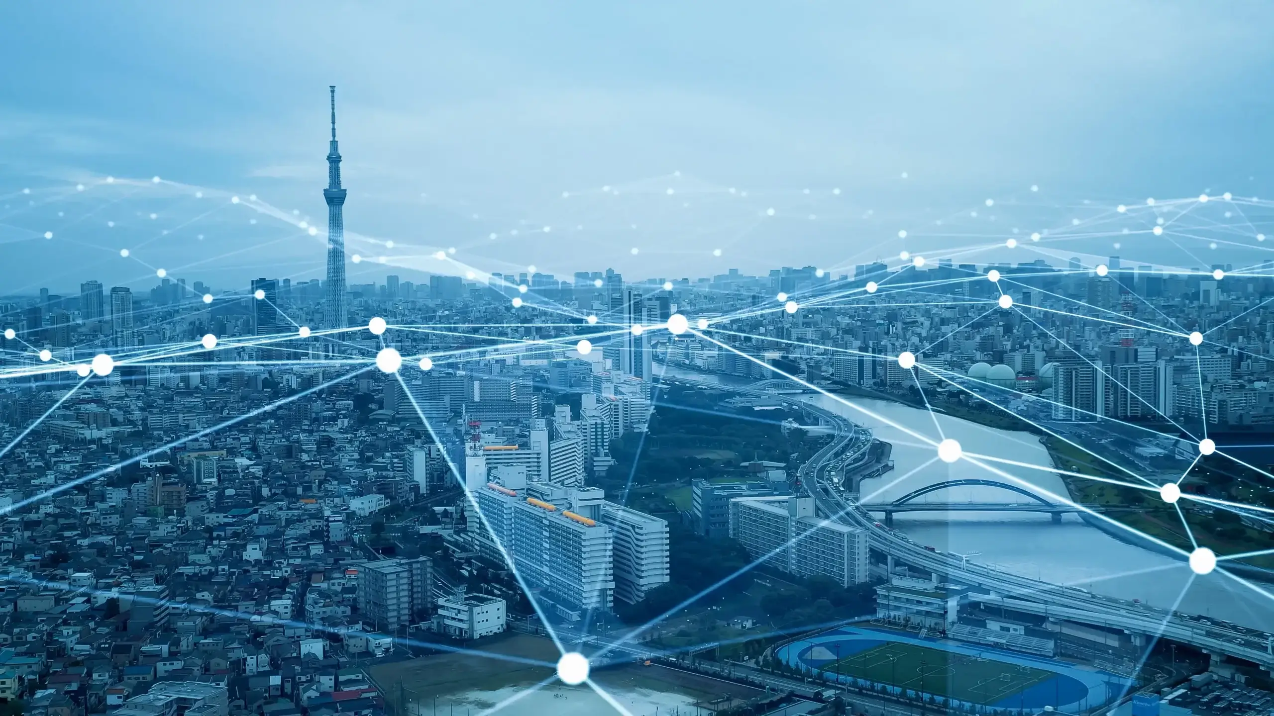 Wide aerial view of a sprawling cityscape overlaid with a glowing digital network of interconnected nodes and lines.